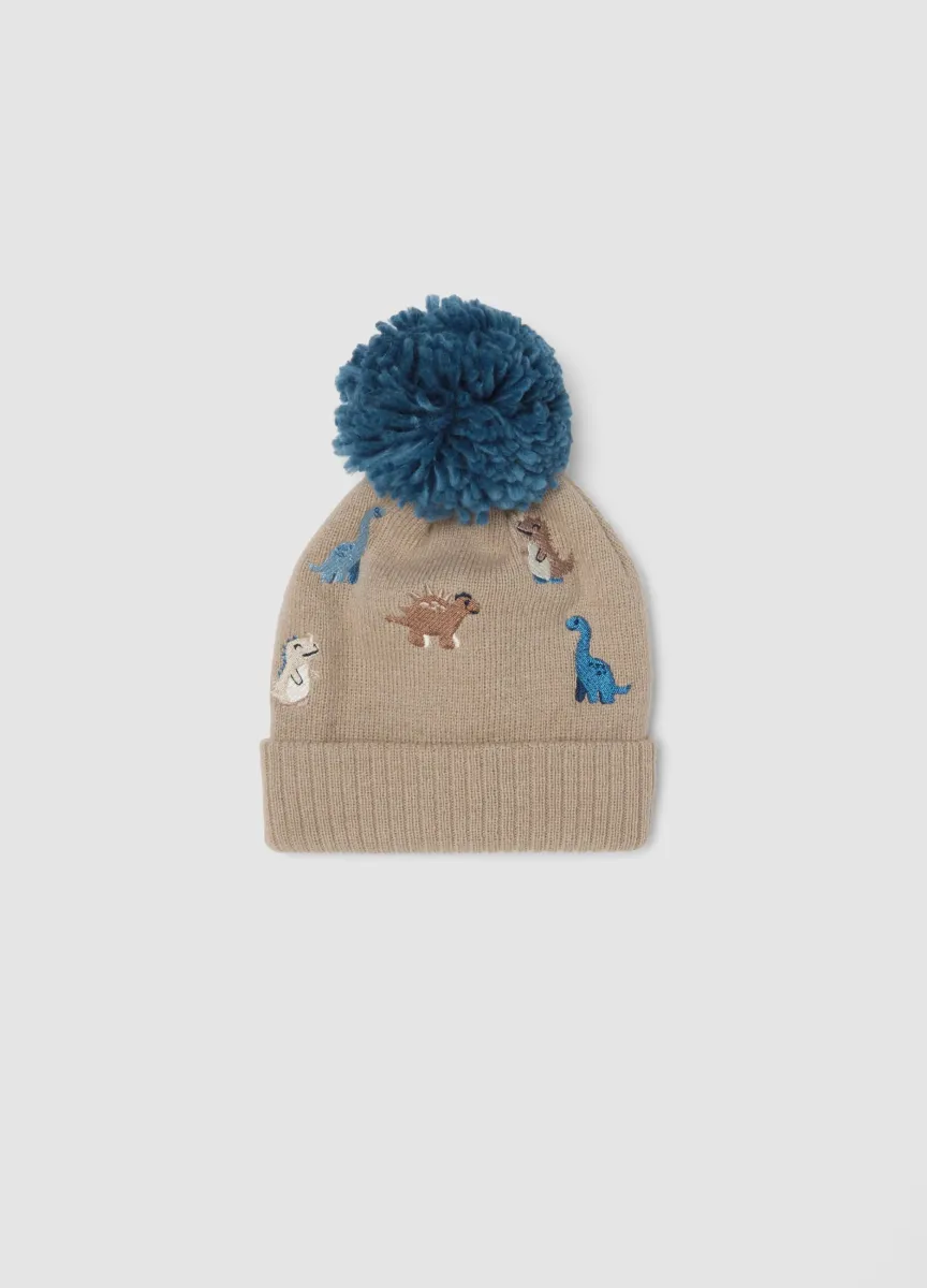 Cappello beige con pon pon e dinosauri