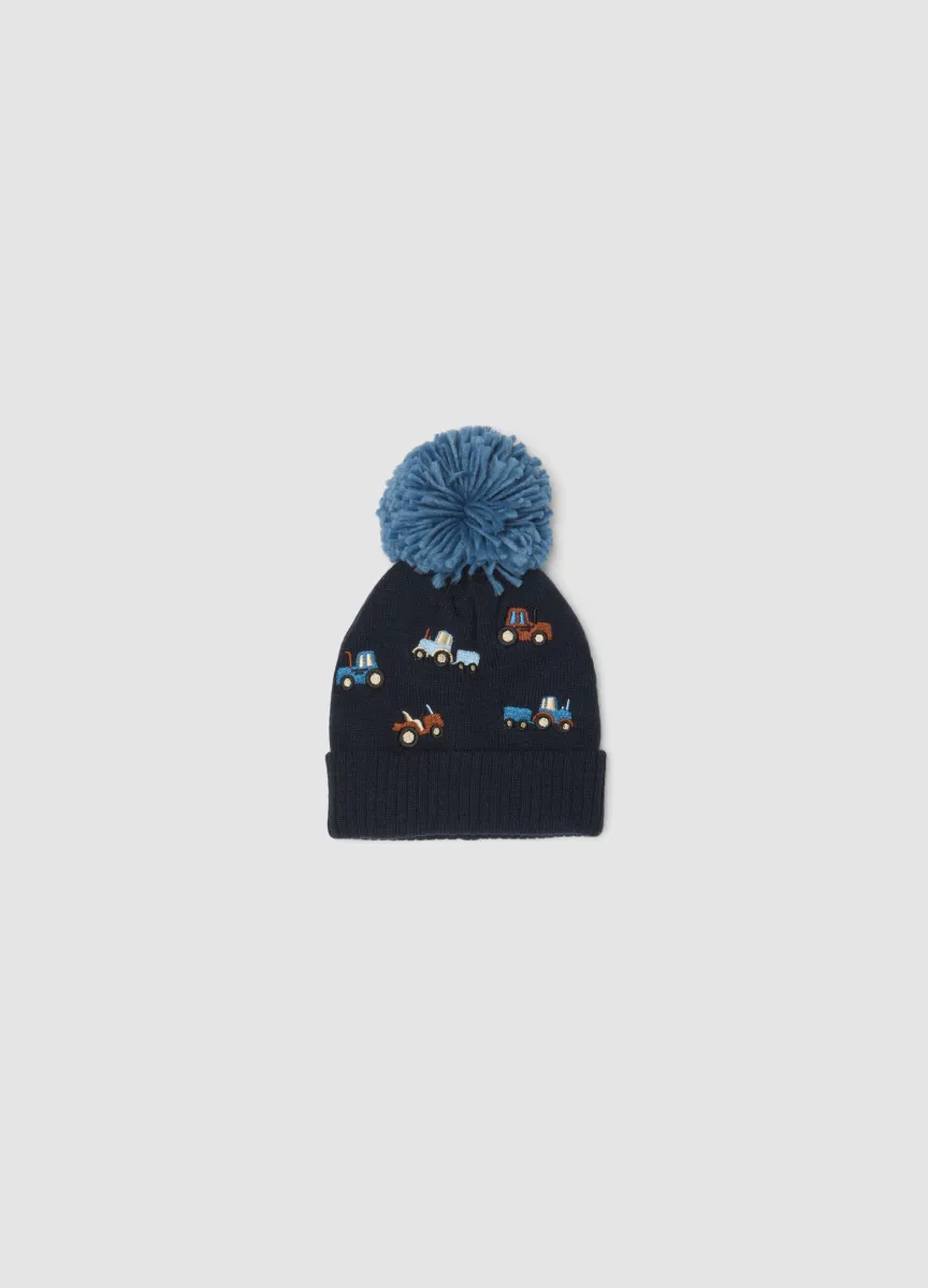 Cappello blu in maglia con pompon e ricami di trattori