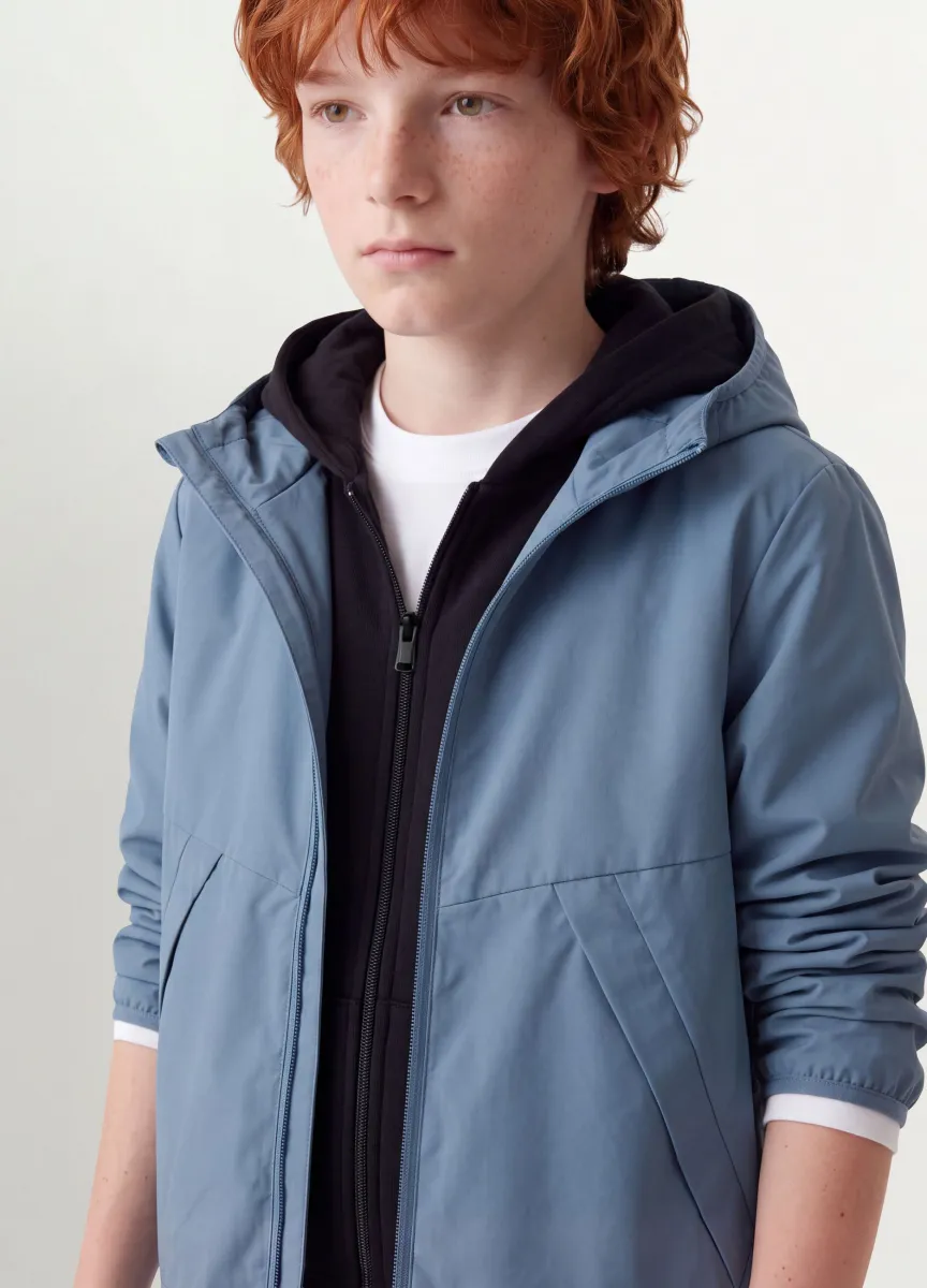 Giacca antipioggia over fit blu con cappuccio e zip per ragazzo
